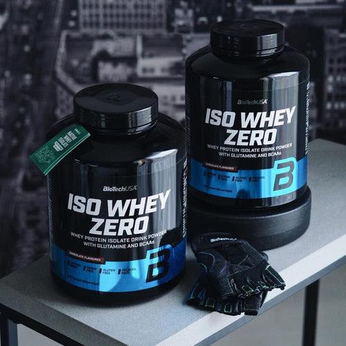 Black tubs of Biotech USA Iso Whey Zero Lactose Free protein powder with workout gloves