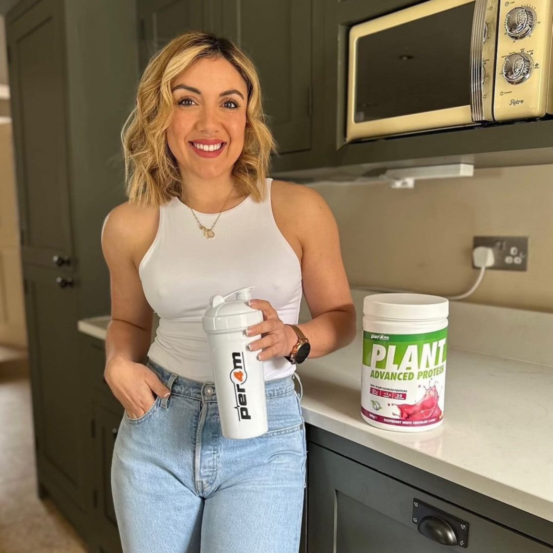 Smiling blonde woman with Per4m Plant Protein 908g dairy free and plant-based powder