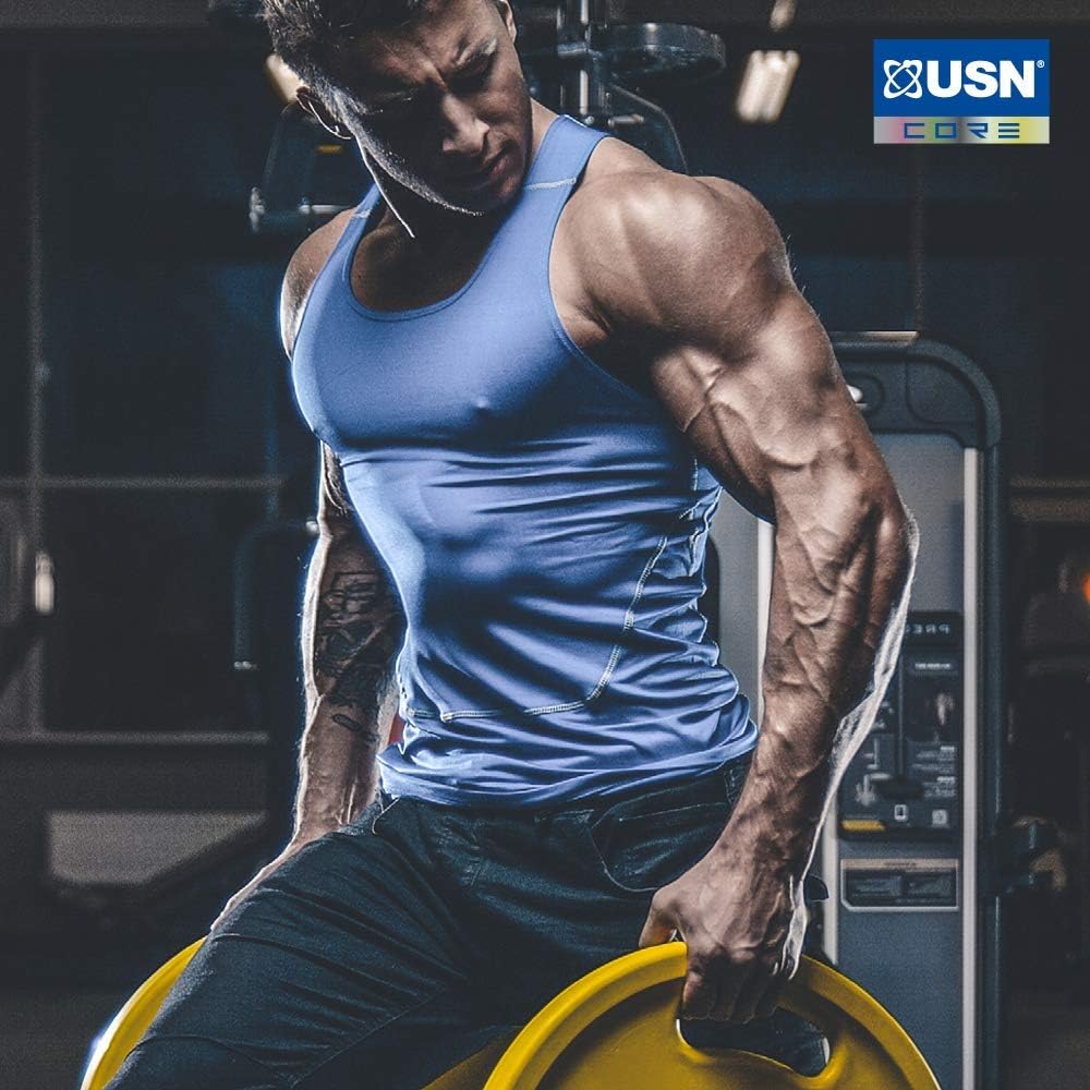 Muscular man in blue tank top holding yellow weights with USN Tornado Shaker for leak-proof blending