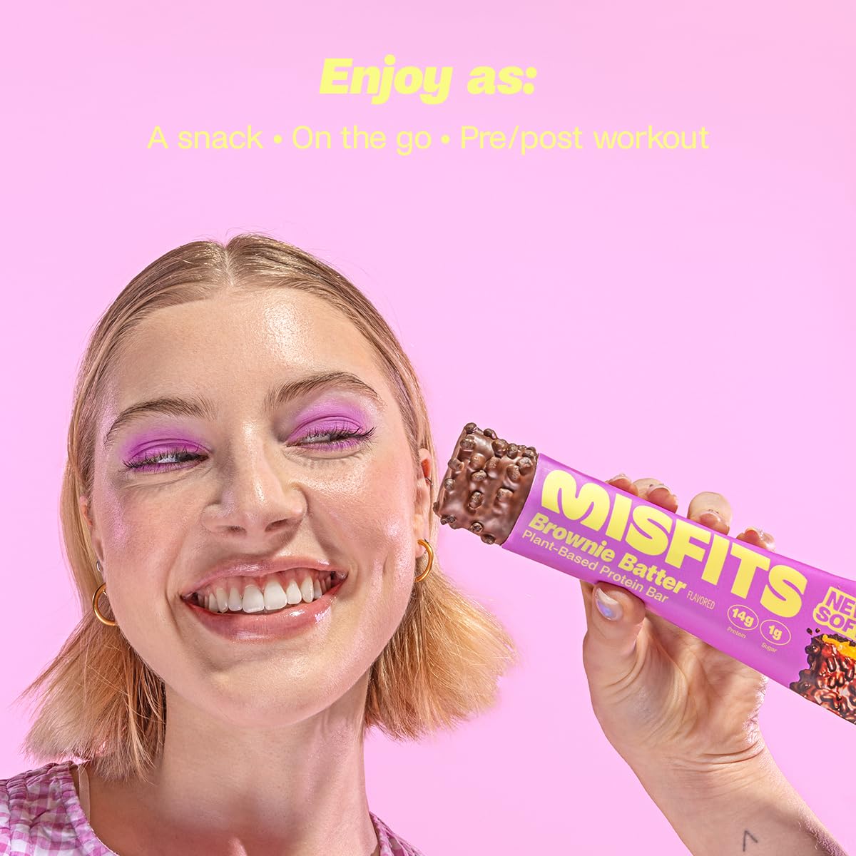 Smiling woman holding Misfits Plant-Based Protein Bar, a tasty plant-based protein bar