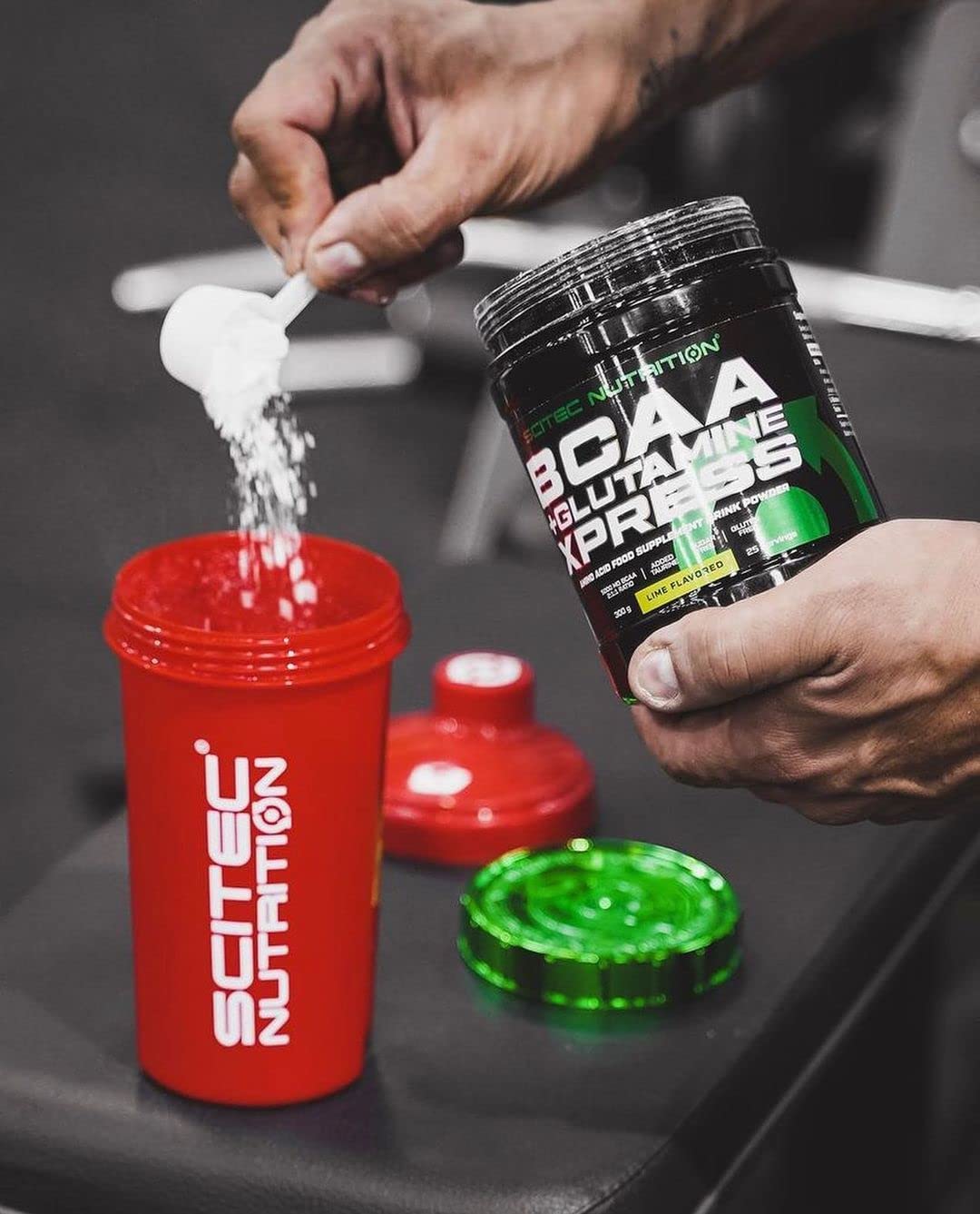 Red shaker bottle with white lid filling with glutamine xpress amino acids from Scitec Nutrition BCAA