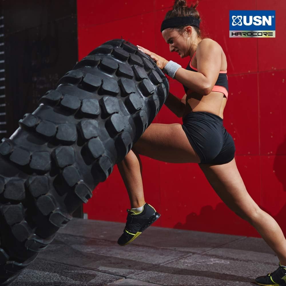 Woman in athletic wear pushing a tire with USN Tornado Shaker for leak-proof blending powders