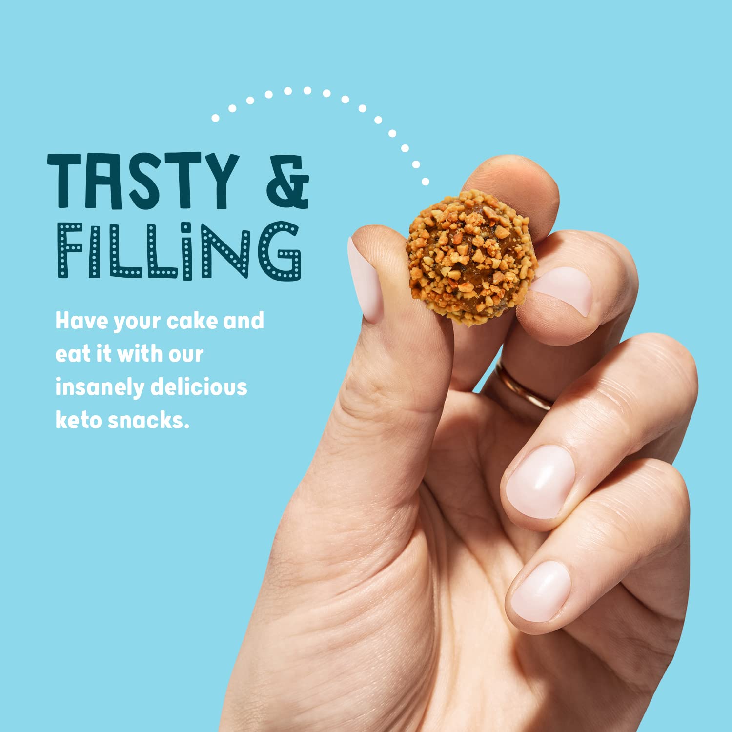 Keto balls protein snack with textured peanut butter flavor held between fingers