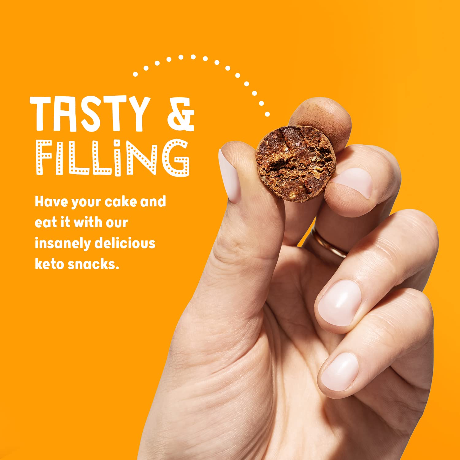 Hand holding a chocolate-colored keto ball snack from The Protein Ball Co Keto Ball Snack, a tasty peanut butter snack