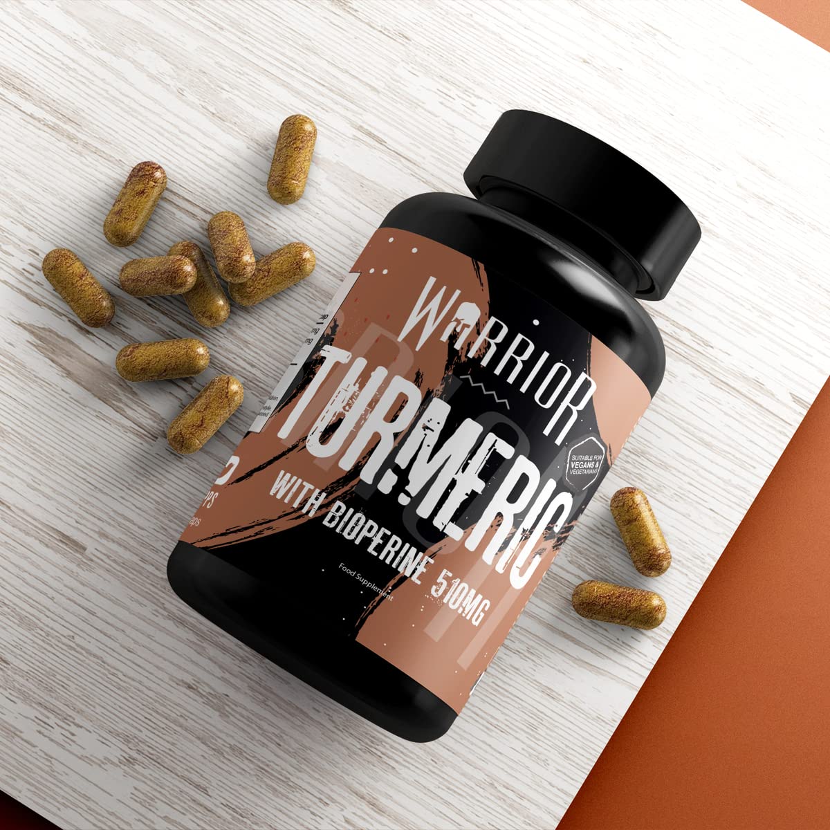 Black plastic bottle of Warrior Core Turmeric & Bioperine capsules with organic 500mg turmeric and 10mg Bioperine