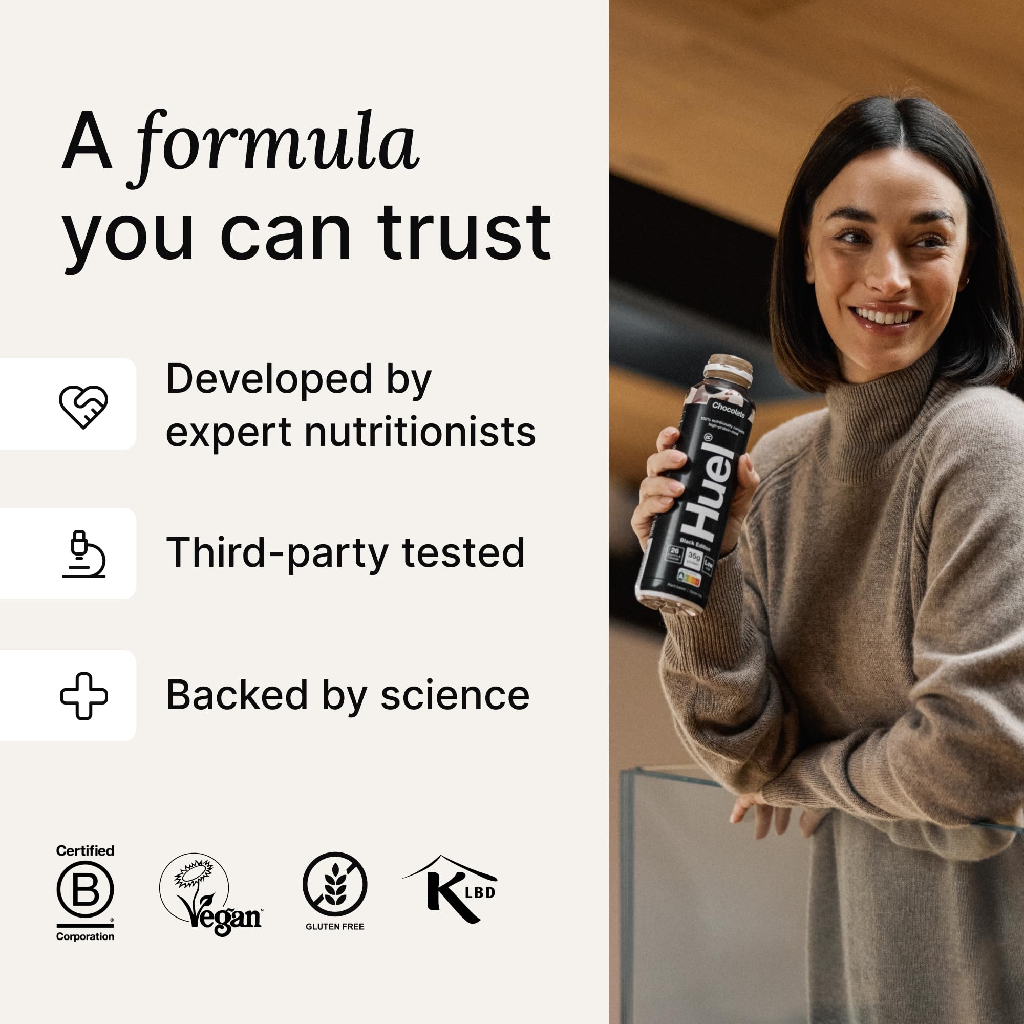 Woman holding Huel Ready-to-Drink Black Edition 8x500ml Chocolate Peanut Butter bottle