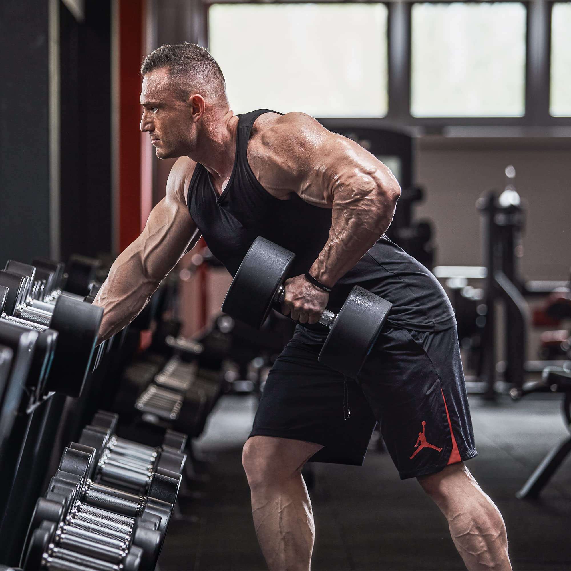 Man working out with dumbbell at gym for Scitec Nutrition Proteinissimo Prime chocolate coating