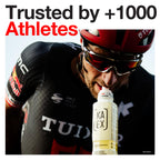 Male cyclist in black and red uniform drinking from yellow bottle for muscle gain and amino acids boost