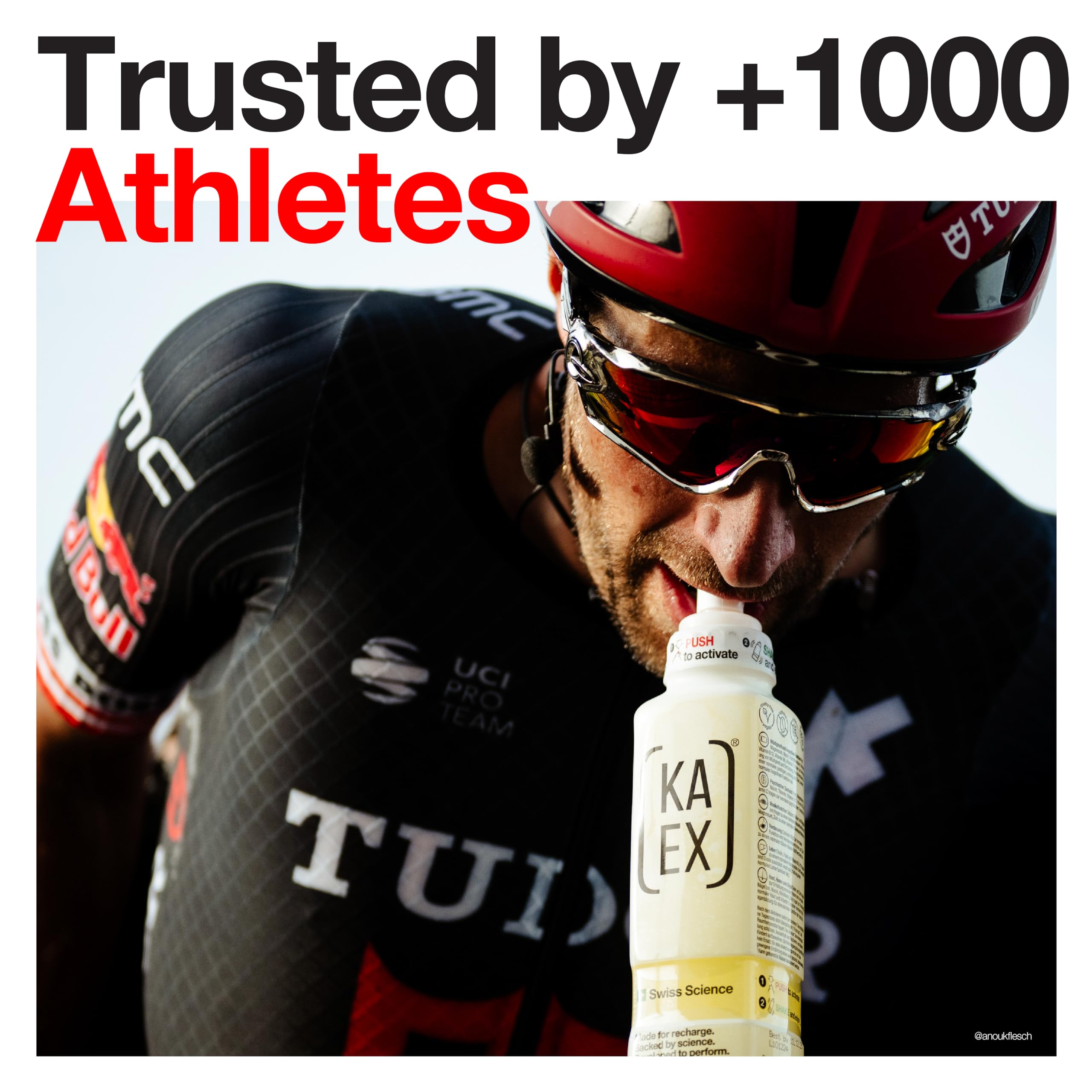 Male cyclist in black and red uniform drinking from yellow bottle for muscle gain and amino acids boost