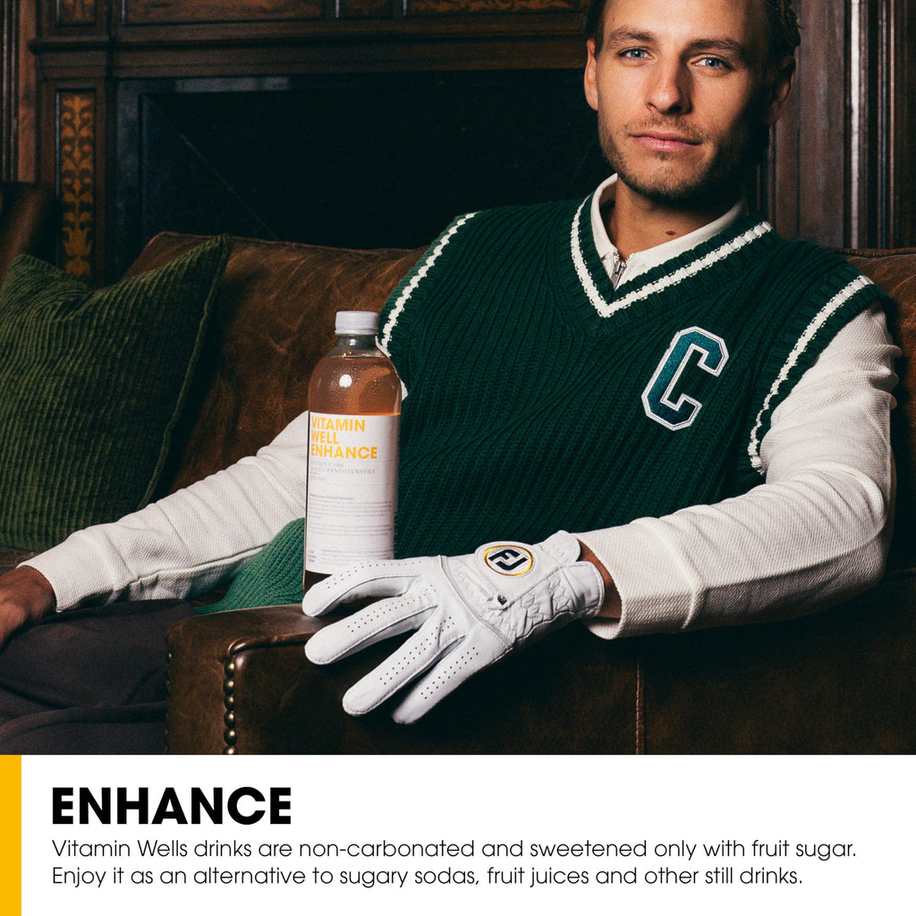 Man in green sweater vest holding Vitamin Well Enhance Orange for combat fatigue and healthy lifestyle