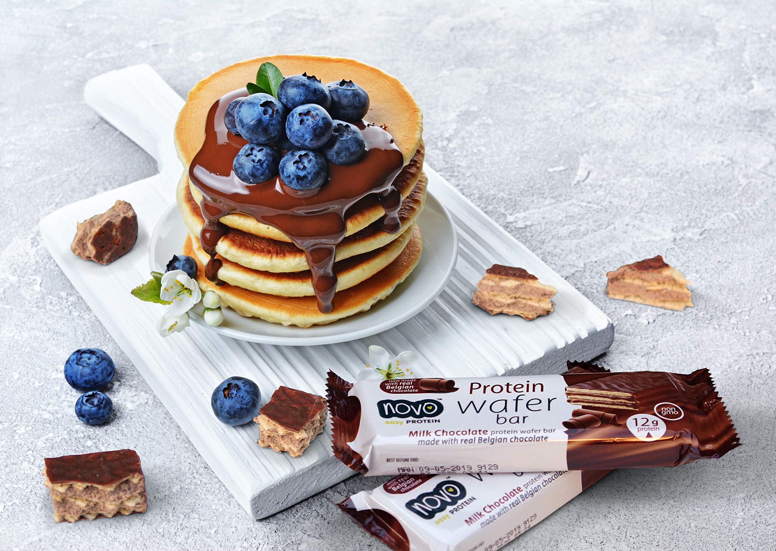 Stack of pancakes with blueberries and chocolate syrup next to Novo Nutrition Novo Protein Wafer Bar