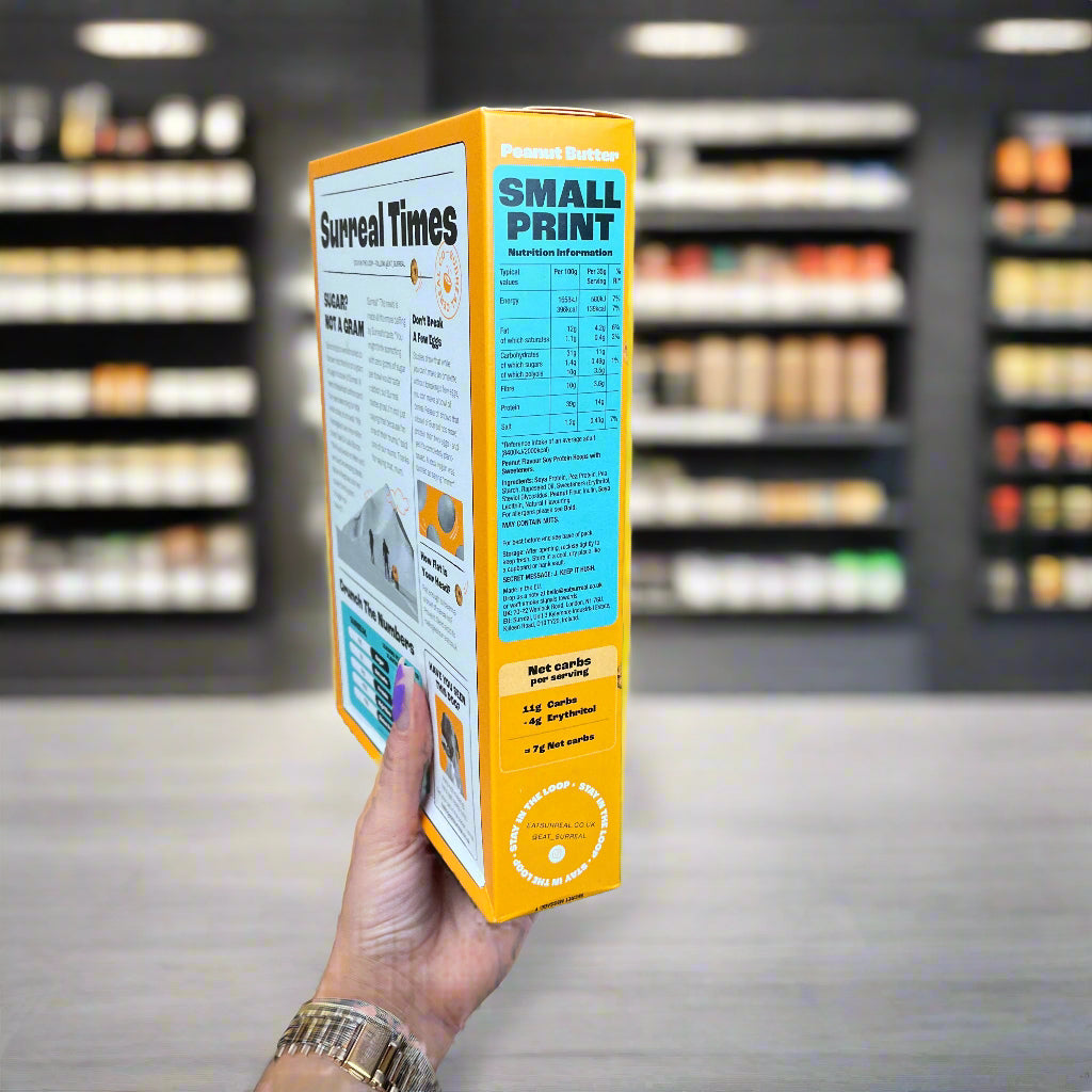 SURREAL Protein Cereal box with Surreal Times newspaper design and small print nutrition facts