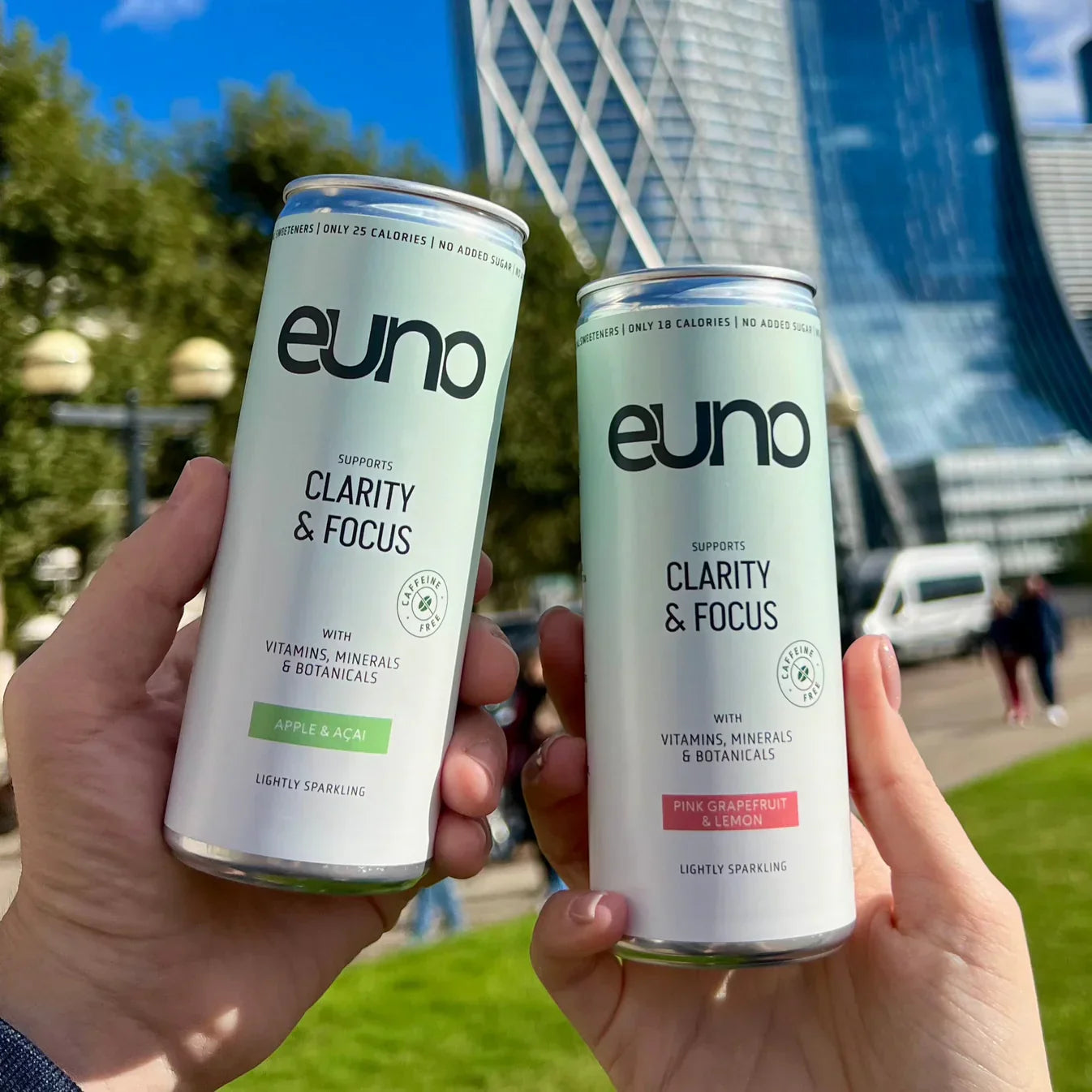 Hands holding Euno Clarity & Focus nootropics drink cans with Lion’s Mane and vitamins
