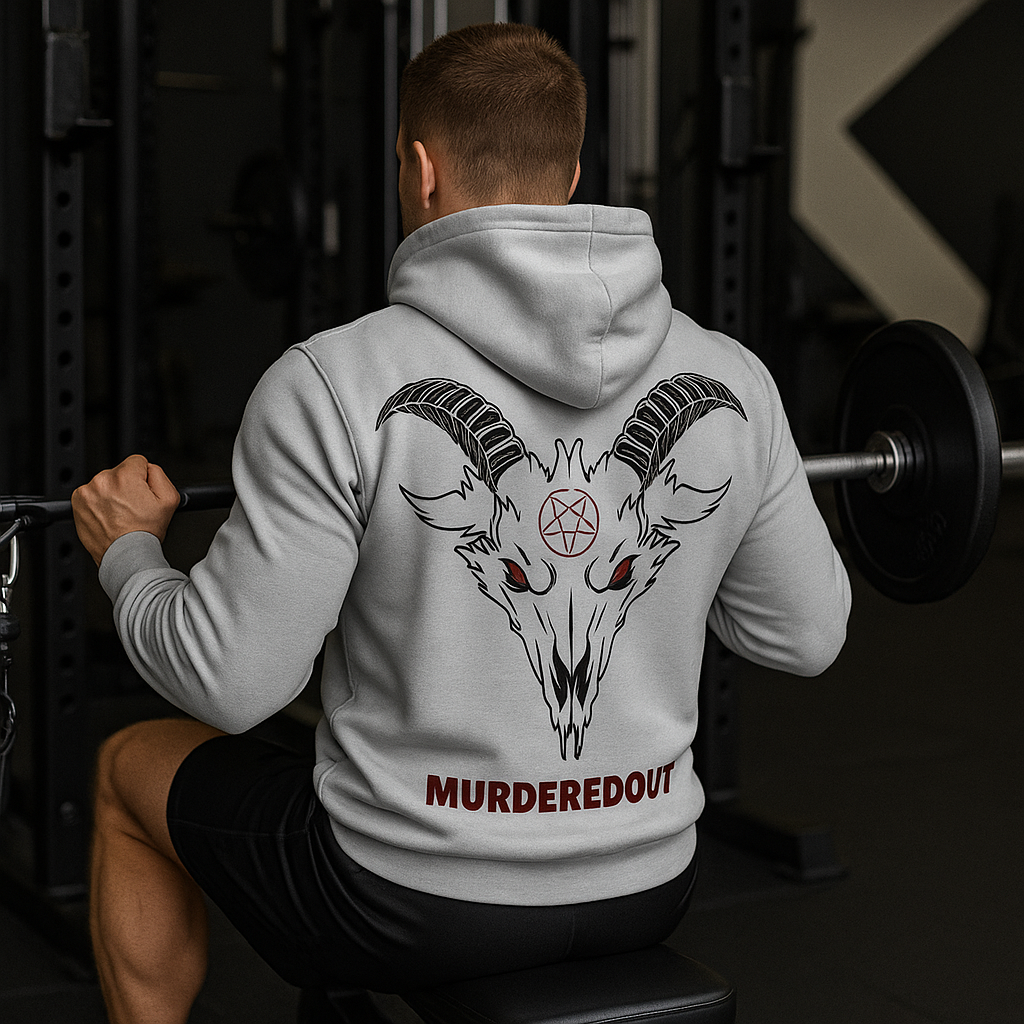 Person wearing a hoodie with a goat skull design and 'MURDEREDOUT' text in a gym setting.