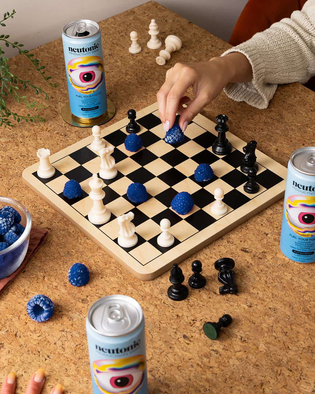 Chess board with white black pieces and blue berry-like pieces for Neutonic Productivity Drink featuring Rhodiola Rosea and Panax Ginseng