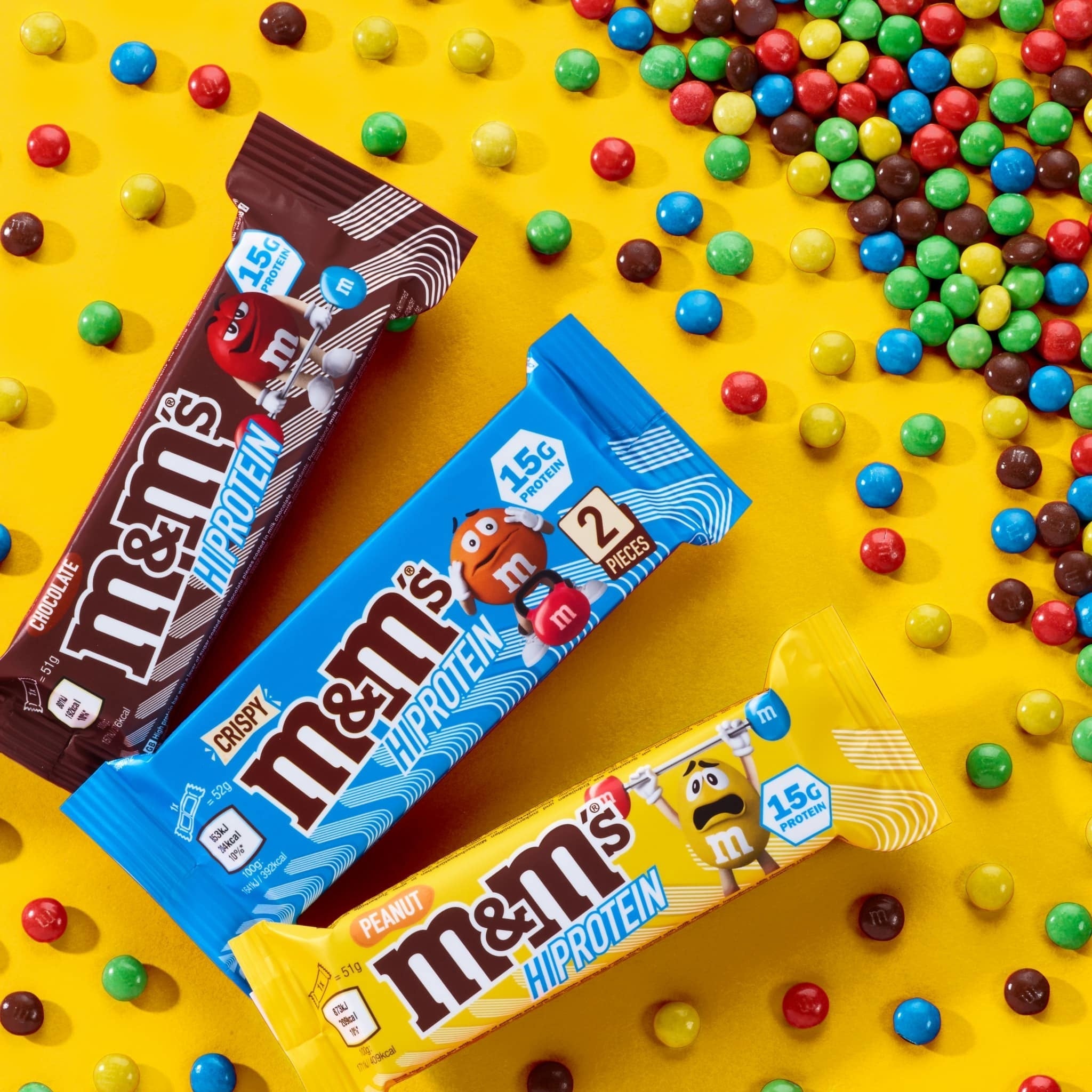 Three M&M Hi-Protein Bars in different flavors on display showcasing the M&M Hi-Protein Bar