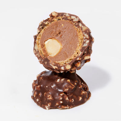 Cross-section of LoveRaw Nutty Choc Balls showing a whole hazelnut center, perfect vegan chocolate indulgence