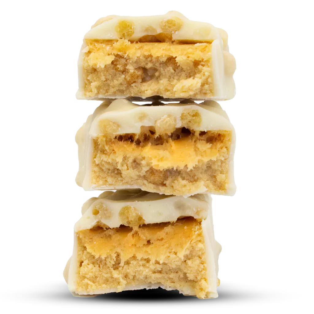 Stack of Per4m Protein Bar white chocolate peanut butter dessert bars with crunchy base