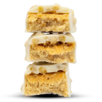 Stack of Per4m Protein Bar white chocolate peanut butter dessert bars with crunchy base