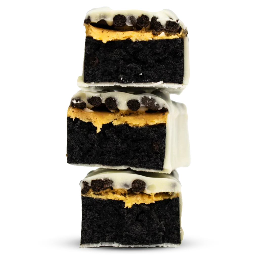 Per4m Protein Bar featuring stacked dark chocolate fudge brownies with peanut butter and white chocolate topping
