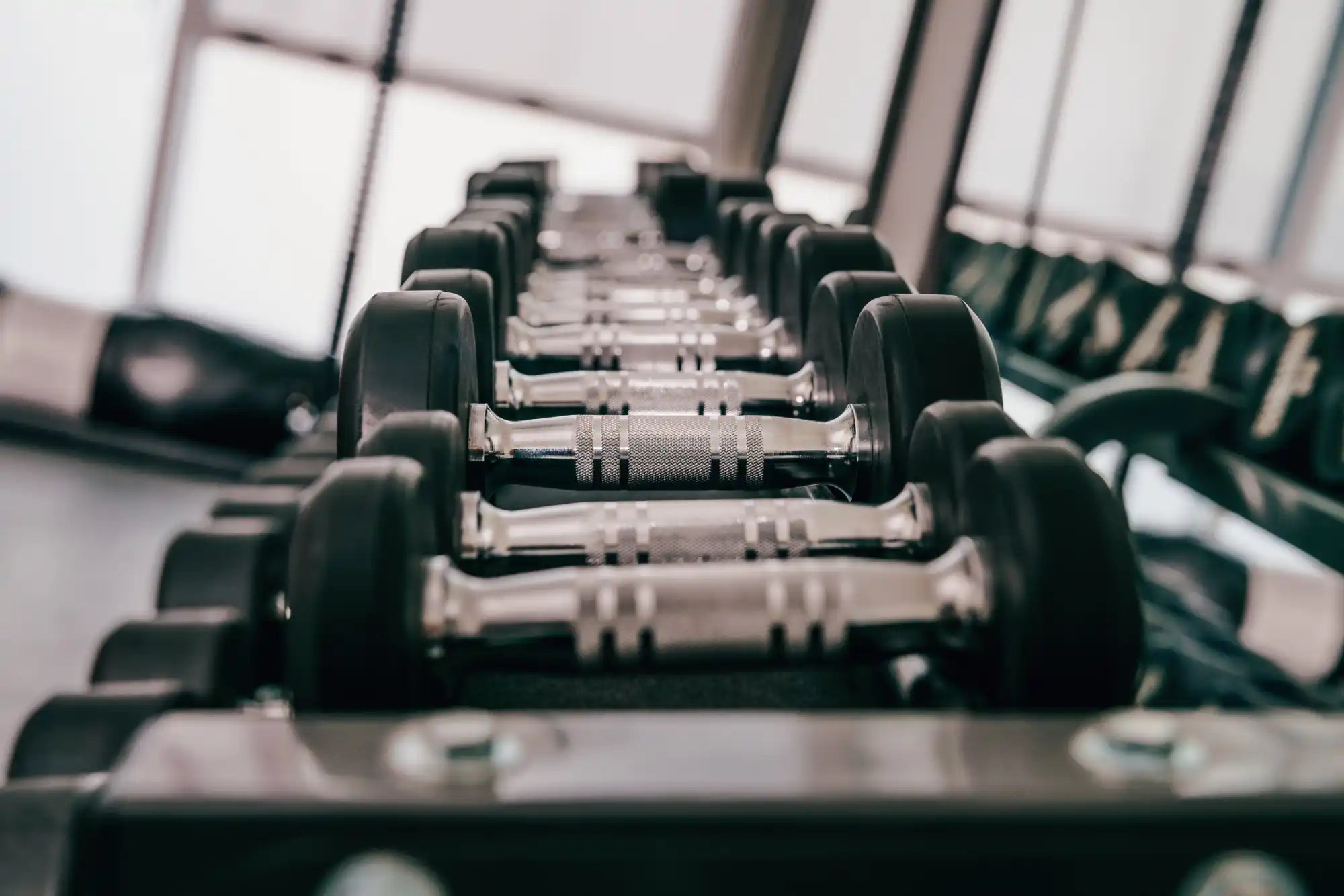 A rack of black and silver dumbbells.